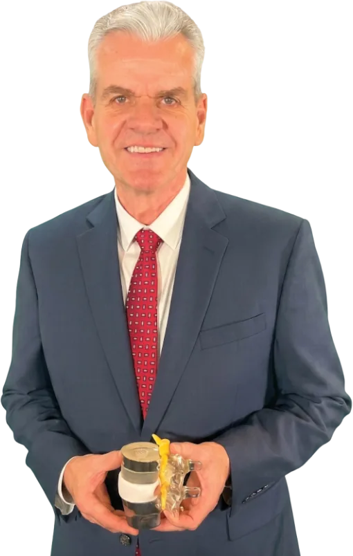 Dr. Gordon Stapel, DC, in a suit, holding a model of the spine